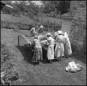 Primary view of object titled '[Women at an outdoor quilting bee]'.