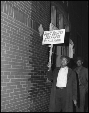 Primary view of object titled '[A man holding a sign]'.