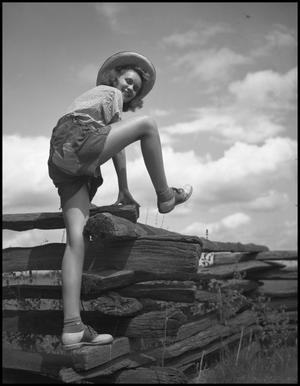 Primary view of object titled '[A woman climbing a fence]'.