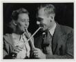 Photograph: [Couple Sampling the molasses with Sop Sticks]