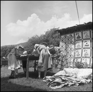 Primary view of object titled '[Women sewing at an outdoor quilting bee]'.