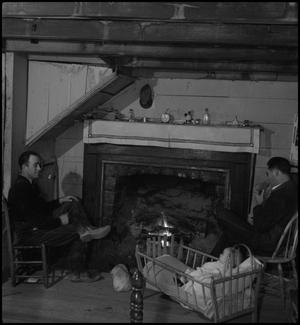 Primary view of object titled '[People sitting by fireside]'.