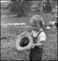 Photograph: [Photograph of a young child unhappily holding a hat with some chicks]