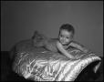 Photograph: [Smiling baby lying on a quilt]
