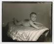 Photograph: [Photograph of a baby lying on its stomach on a quilt]