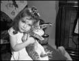 Photograph: [Young girl hugging a kitten]