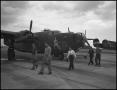 Photograph: [Five people walking through an airfield]
