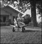 Photograph: [Photograph of a young girl driving a toy plane, 1]