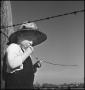 Photograph: [Photograph of a young boy leaning against a fence post]