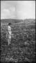 Photograph: [A girl standing in a plowed field]