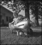 Photograph: [Photograph of a young girl sitting in a toy plane, 1]