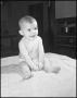 Primary view of [Photograph of a baby sitting up on a bed]