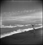 Photograph: [Photograph of a girl watching the waves crash on the shore]