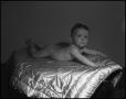 Photograph: [Baby lying on its stomach on a quilt]