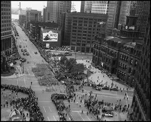 Primary view of object titled '[Aerial photograph of a parade marching downtown, 3]'.
