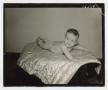 Photograph: [Photograph of a naked baby lying on a quilt]