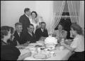 Photograph: [Photograph of a wedding party sitting at a table together]