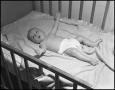 Photograph: [Baby lying in a crib]