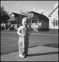 Photograph: [Toddler standing on a sidewalk]