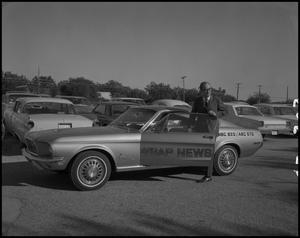 Primary view of object titled '[Bruce Neal poses in the WBAP-TV News Car]'.