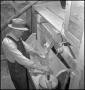 Photograph: [Farmer grinding cornmeal]