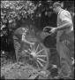 Photograph: [Two men quenching a wheel, 3]
