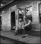 Photograph: [Two men chatting on a porch, 2]