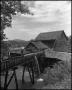 Photograph: [Man admiring a watermill, 2]