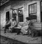 Photograph: [Relaxing on a store's porch, 2]