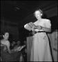 Photograph: [Woman singing from a hymnbook]