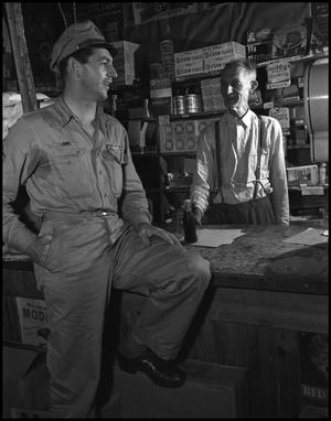 Primary view of object titled '[Cashier talking with a serviceman]'.