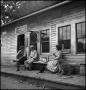 Photograph: [Relaxing on a store's porch, 3]