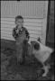 Primary view of [Photograph of a boy outside with his dog]