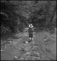 Photograph: [A boy walking down a forested path]