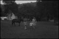 Photograph: [Photograph of a family and their horse walking through a clearing, 1]
