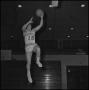 Photograph: [Ron Miller jumping up with basketball in hand]