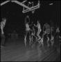 Photograph: [Basketball Players On Coliseum Court During Game]