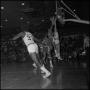 Photograph: [Basketball going into the hoop as players jump]