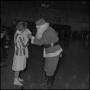 Photograph: [Santa Clause talking to a child on a basketball court]