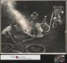 Photograph: [Men building wheels at Alex Cline's blacksmith shop]