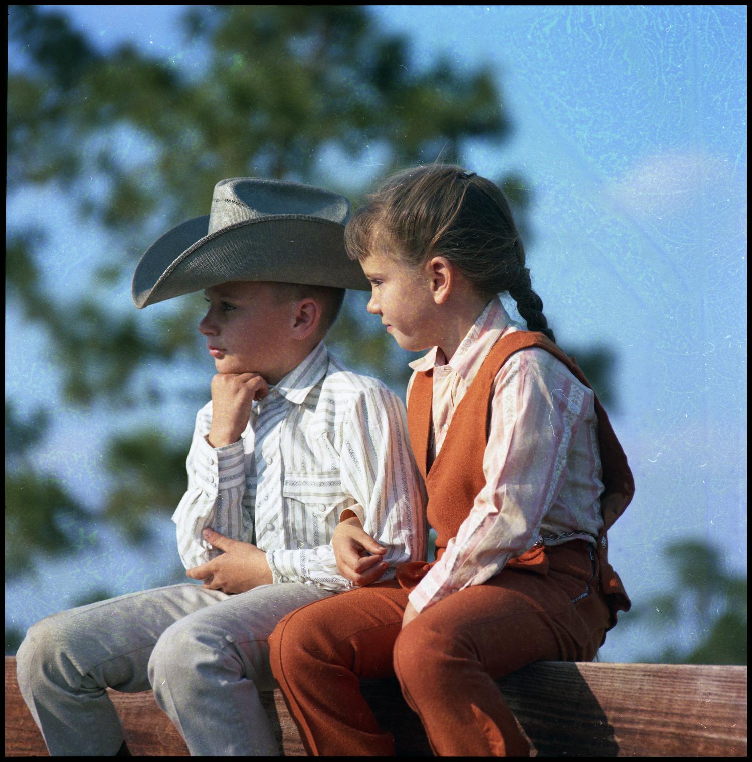 [Boy and girl sitting on a fence], Portrait of two children (a boy and a girl) sitting on a fence, D.R. Daniel Ranch., 