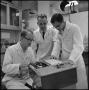 Photograph: [Researchers looking at a readout on machine 1]