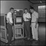 Photograph: [Research participants gathered around large stand alone machine 2]