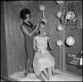 Photograph: [Student putting wig on mannequin]