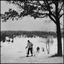 Photograph: [Three people skiing back up a hill]