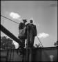 Thumbnail image of item number 1 in: '[Two men standing on top of a trailer]'.