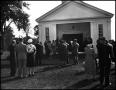 Photograph: [Crowd standing outside of a church for a funeral]