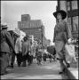 Photograph: [Woman standing on the curb to the sidewalk]