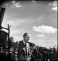 Photograph: [Henry Ford sitting next to a machine]