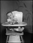 Photograph: [Baby sitting in a highchair]